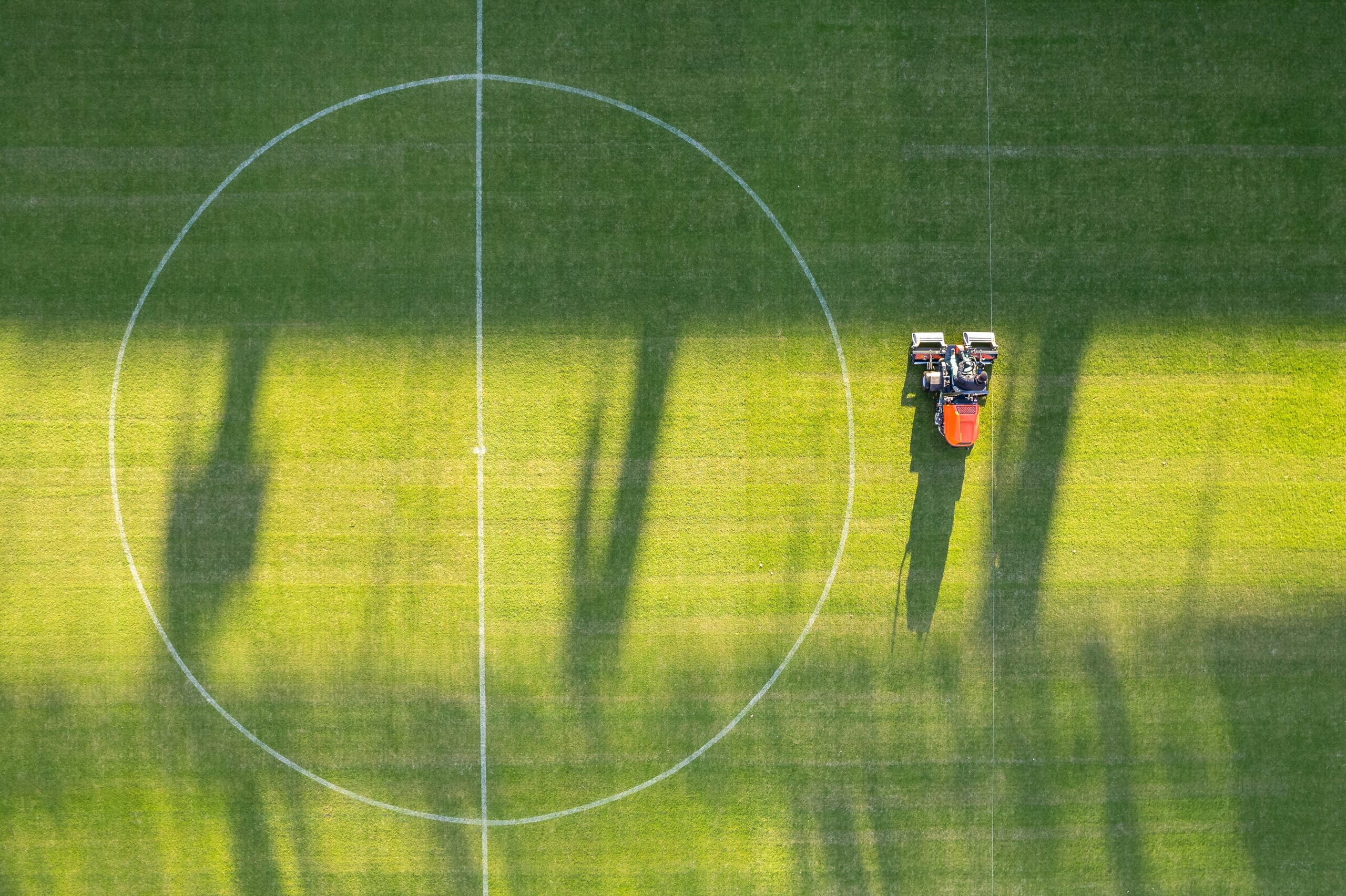 Drone,View,Of,The,Man,Moving,Grass,At,The,Football